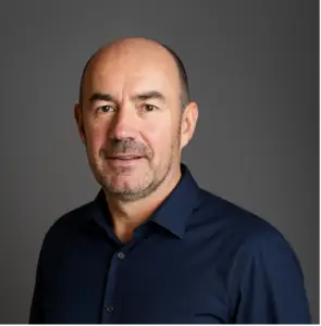 Jon H | Apprenticeship and Training Awards | Apprenticeship and Training Awards Portrait of a middle-aged man with short stubble in a navy shirt against a gray studio backdrop.