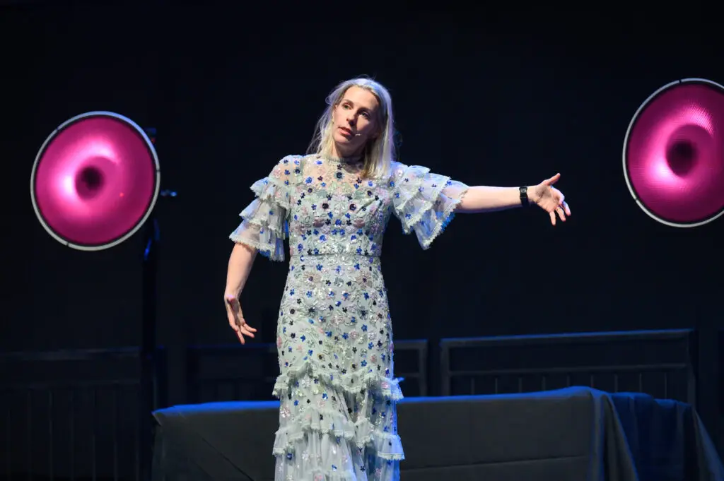 Presenter in a patterned dress on stage at the Apprenticeship and Training Awards 2026.