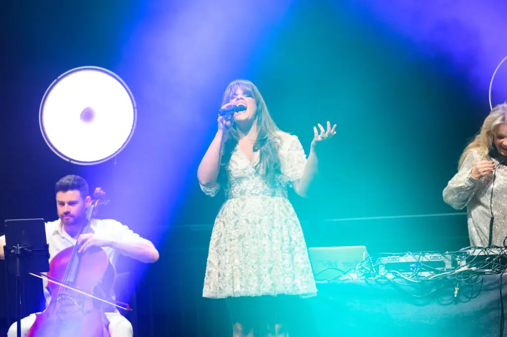 Singer performing on stage with a cellist under pink and blue lights at the Apprenticeship and Training Awards 2026.